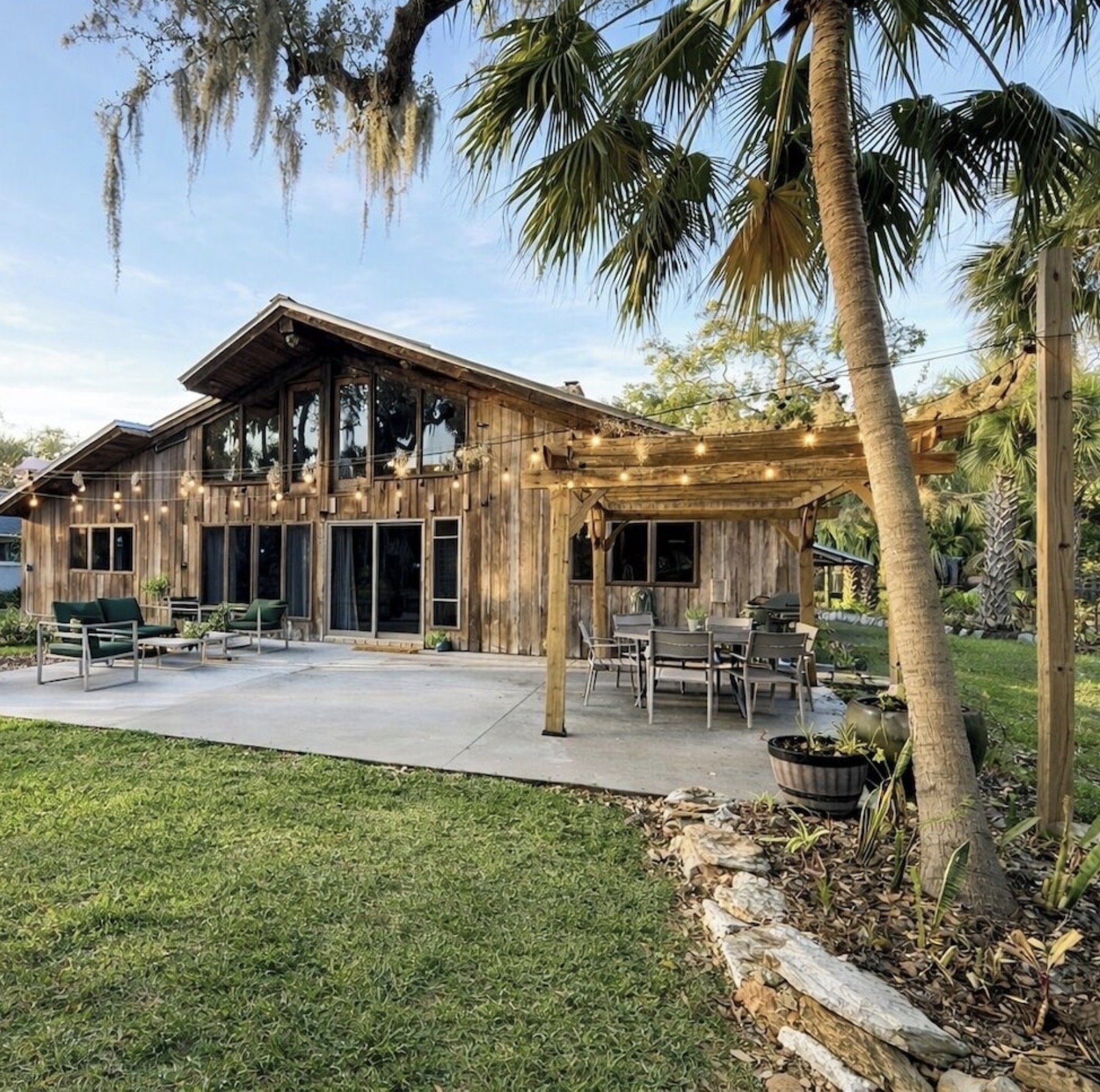 Back Patio & Pergola — Covered outdoor dining and lounge under string lights