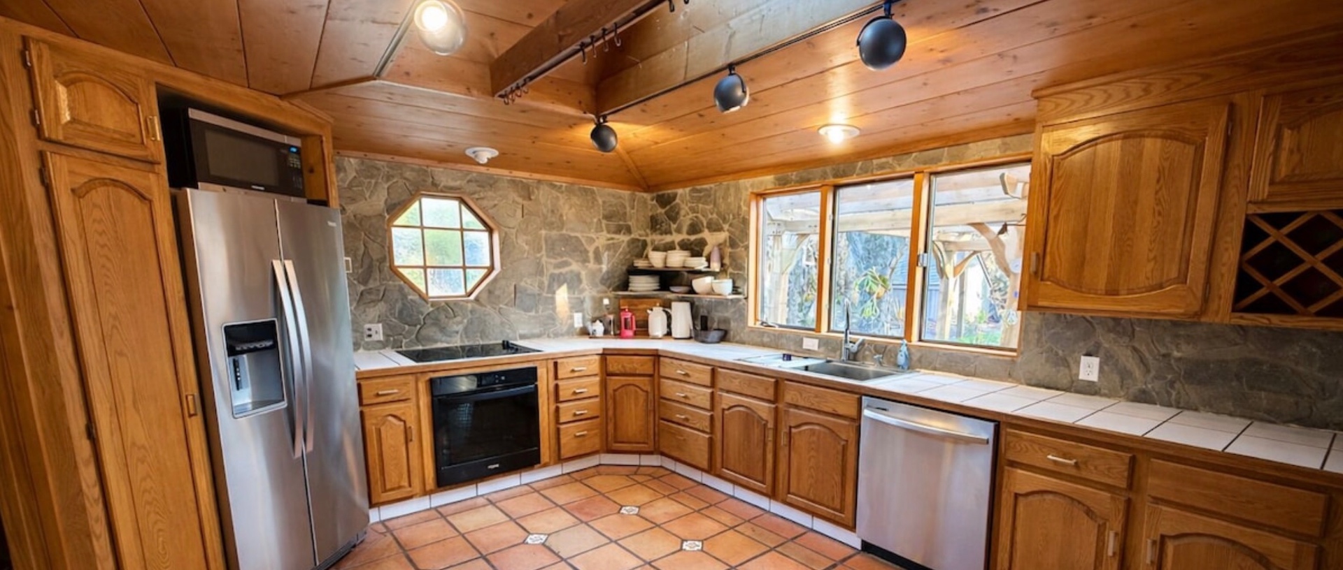 Chef's kitchen with stainless appliances and stone backsplash
